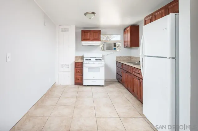 a kitchen with a stove top oven and refrigerator