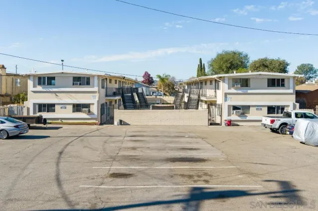 a front view of a building with cars parked