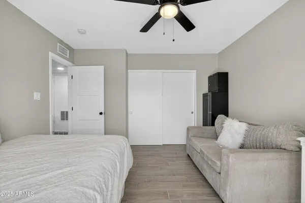 a bedroom with a large bed and ceiling fan