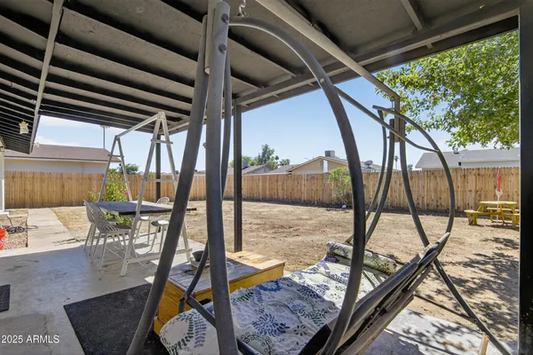 a view of swimming pool with chairs and wooden fence