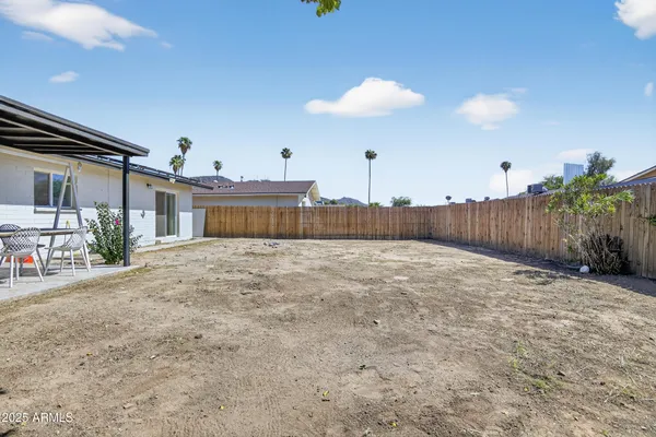 a view of a house with backyard and a tree