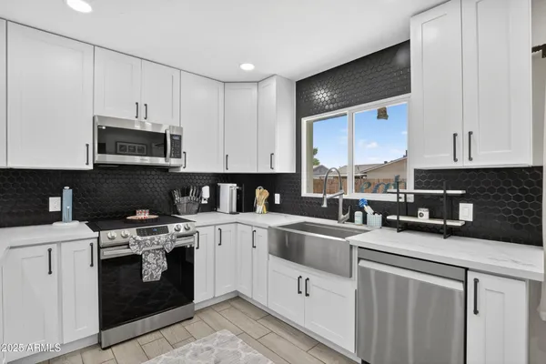 a kitchen with stainless steel appliances granite countertop a stove sink microwave and cabinets