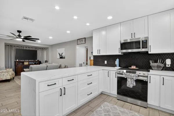 a kitchen with stainless steel appliances granite countertop a stove sink and cabinets