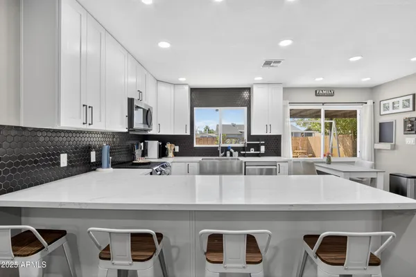 a view of kitchen with kitchen island a stove a sink and a refrigerator