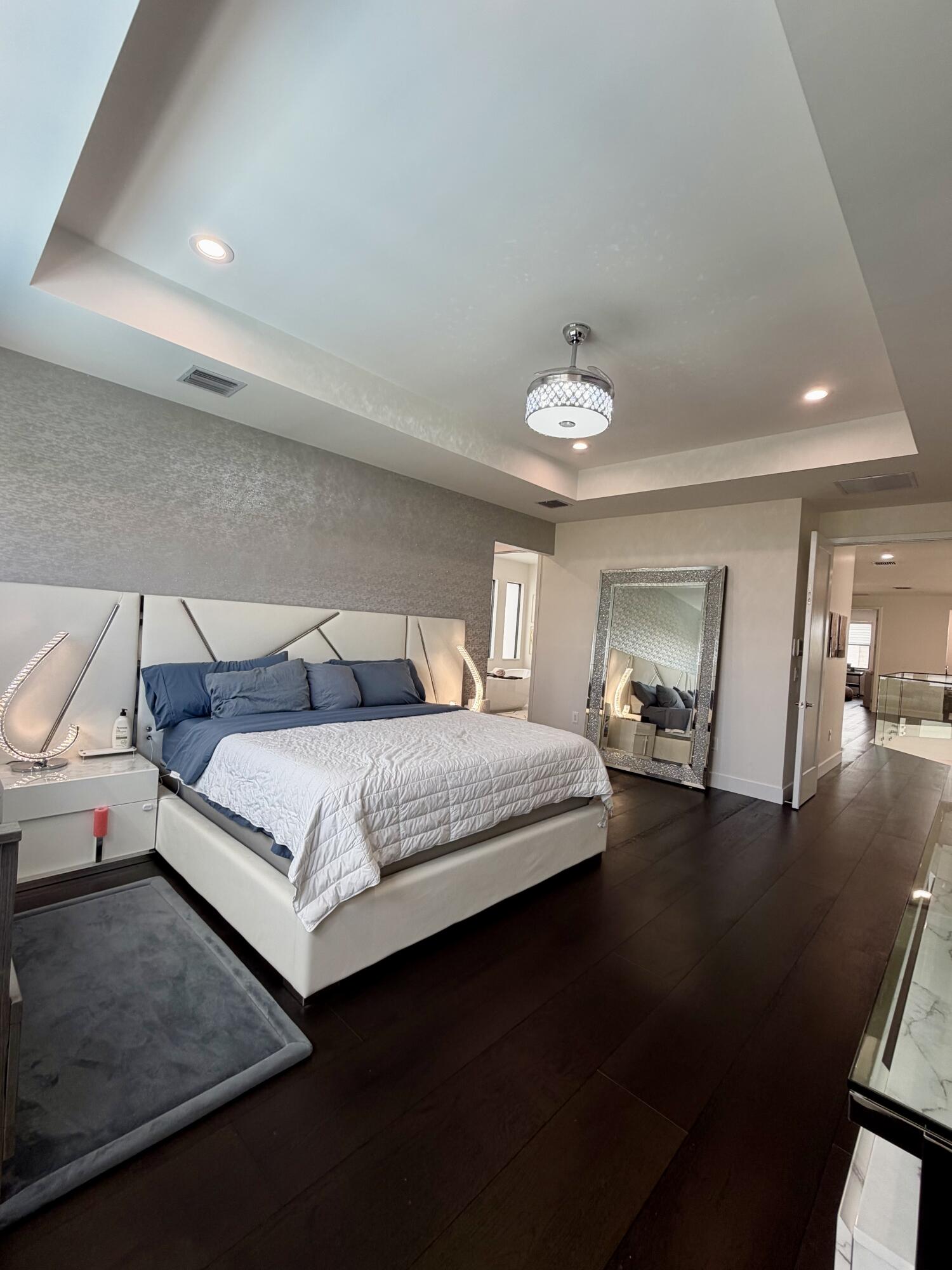 8573 Crystal Downs Avenue Boca Raton, FL 33434 - Photo 46 of 82 a bedroom with a bed and a chandelier