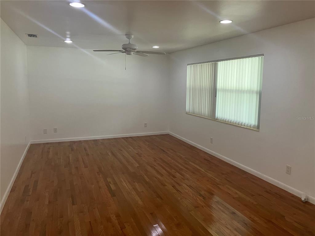 3808 Broad Street Seffner, FL 33584 - Photo 4 of 9 an empty room with wooden floor and windows