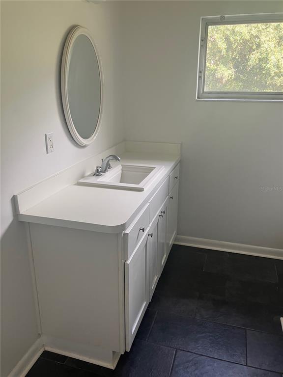 3808 Broad Street Seffner, FL 33584 - Photo 9 of 9 a bathroom with a sink and a mirror