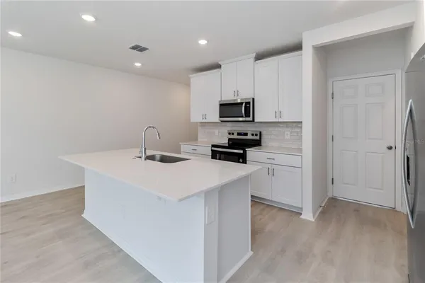 a kitchen with kitchen island a sink appliances and cabinets