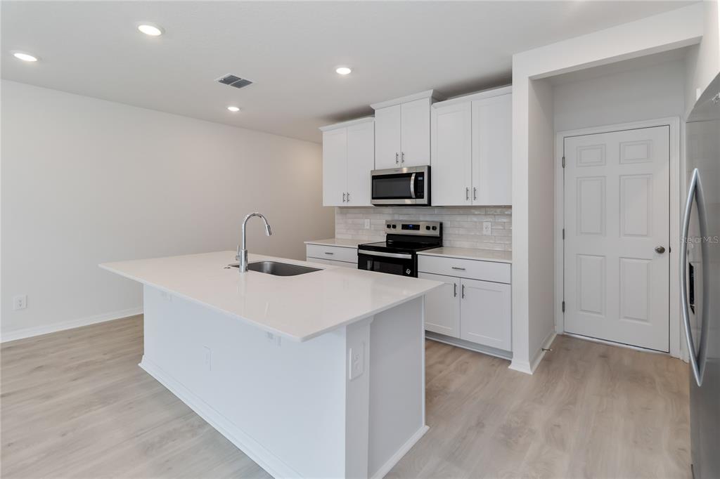 4569 Range Land Way St. Cloud, FL 34772 - Photo 11 of 41 a kitchen with kitchen island a sink appliances and cabinets