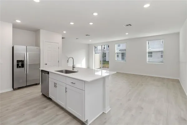 a kitchen with stainless steel appliances granite countertop a sink a refrigerator and a stove