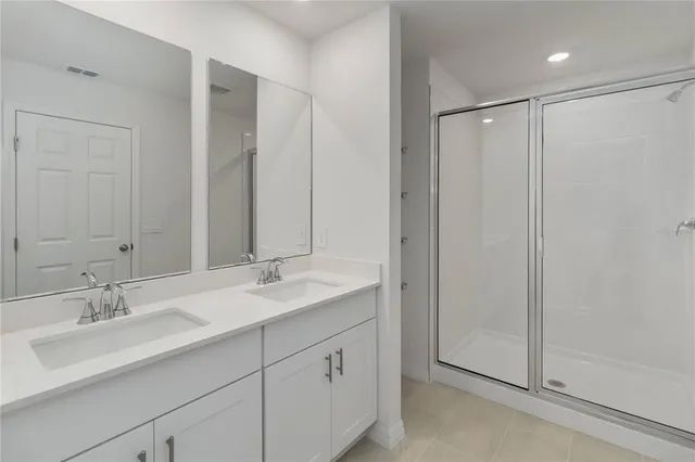 a bathroom with double sink and a mirror