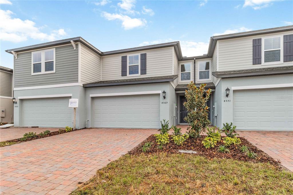 4569 Range Land Way St. Cloud, FL 34772 - Photo 2 of 41 a front view of a house with a yard and garage