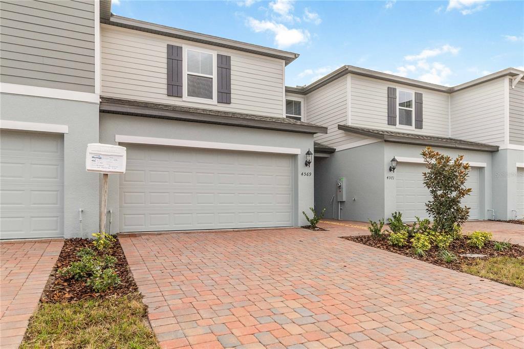 4569 Range Land Way St. Cloud, FL 34772 - Photo 30 of 41 a front view of a house with a yard and garage