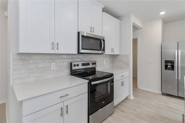 a kitchen with cabinets stainless steel appliances and a counter space