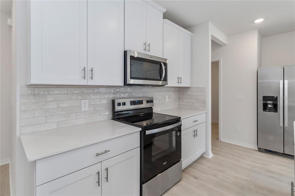 4569 Range Land Way St. Cloud, FL 34772 - Photo 3 of 41 a kitchen with cabinets stainless steel appliances and a counter space