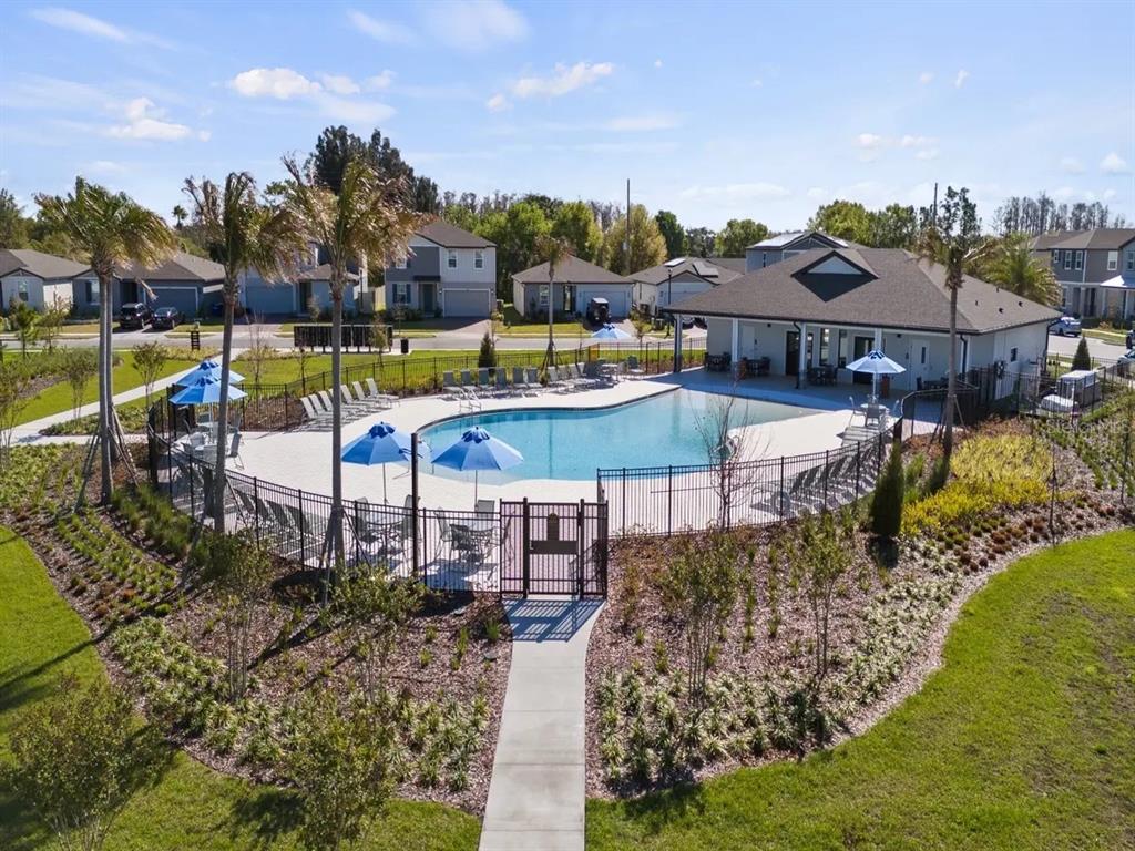 4569 Range Land Way St. Cloud, FL 34772 - Photo 37 of 41 a view of a swimming pool with outdoor seating and a garden