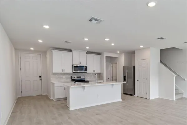 a kitchen with stainless steel appliances a refrigerator and a stove top oven