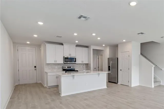a kitchen with stainless steel appliances a refrigerator and a stove top oven