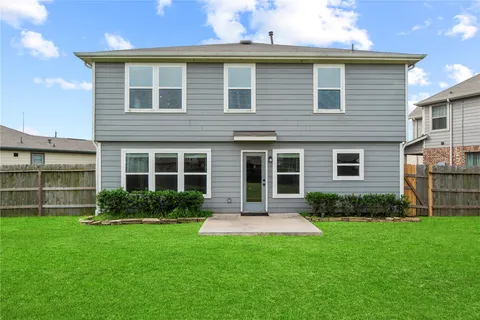 a front view of a house with a yard and green space