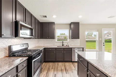 a kitchen with stainless steel appliances granite countertop a sink stove and refrigerator