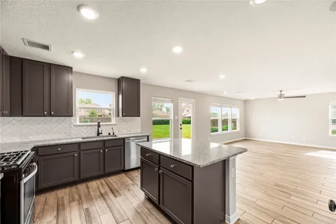 a large kitchen with kitchen island granite countertop a sink counter space and appliances