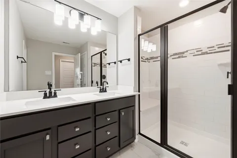 a bathroom with a double vanity sink and mirror with shower