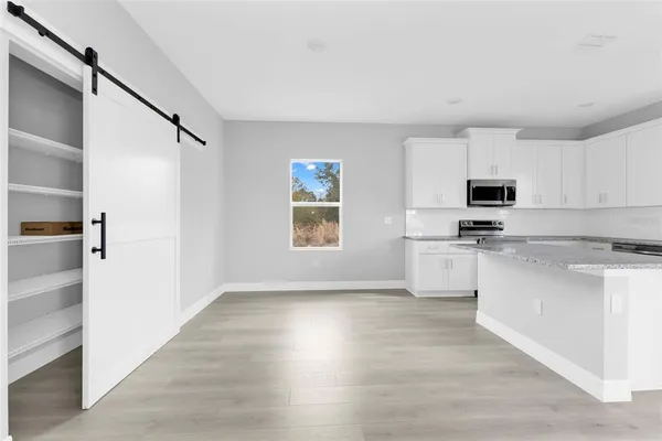 a kitchen with stainless steel appliances a white cabinets and a refrigerator