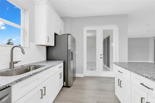 a kitchen with stainless steel appliances granite countertop a refrigerator and a sink