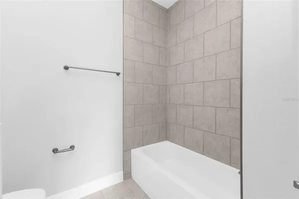 a bathroom with a granite countertop sink a toilet and bathtub