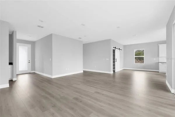 a view of an empty room with wooden floor