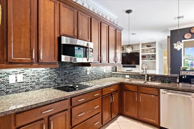 a kitchen with stainless steel appliances granite countertop a refrigerator and stove