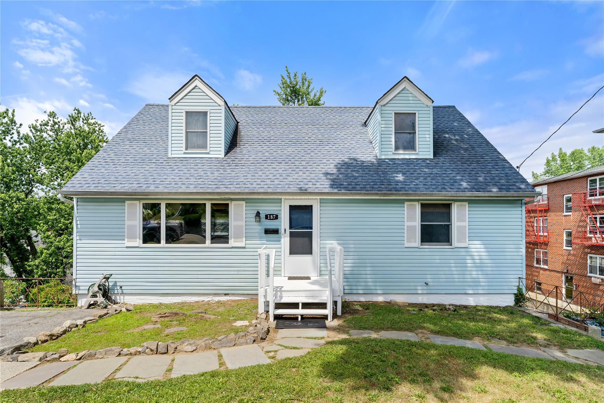 a front view of a house with a garden and yard