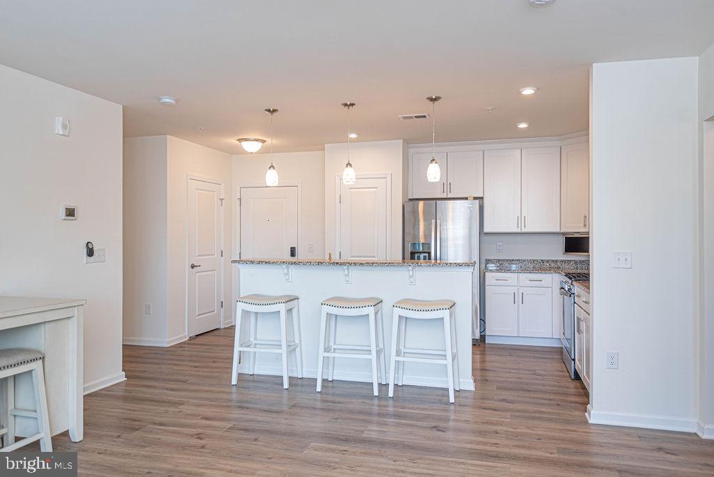 20141 Riesling Lane, Unit 106 Lewes, DE 19958 - Photo 12 of 31 a kitchen with white cabinets and stainless steel appliances