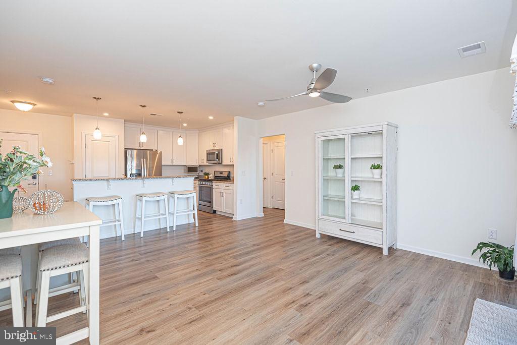 20141 Riesling Lane, Unit 106 Lewes, DE 19958 - Photo 13 of 31 a view of a kitchen with wooden floor and a kitchen