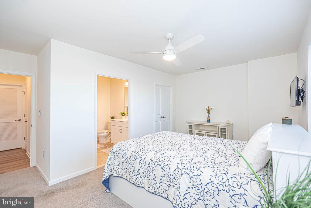 20141 Riesling Lane, Unit 106 Lewes, DE 19958 - Photo 18 of 31 a bedroom with a bed and a chandelier