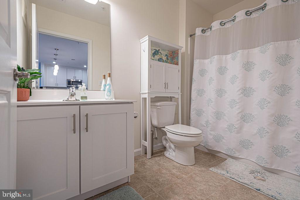 20141 Riesling Lane, Unit 106 Lewes, DE 19958 - Photo 25 of 31 a bathroom with a toilet sink vanity and mirror