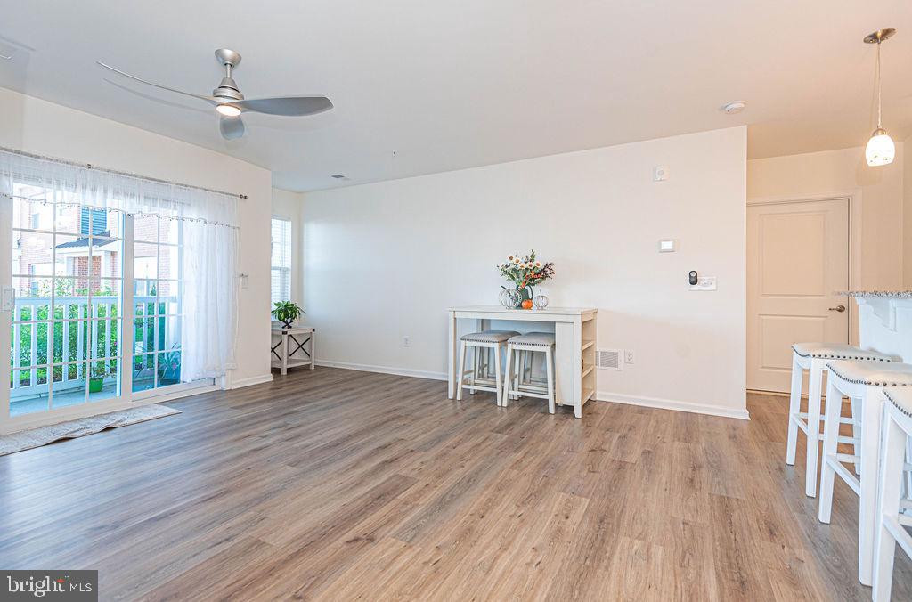 20141 Riesling Lane, Unit 106 Lewes, DE 19958 - Photo 8 of 31 a view of an empty room with a window and wooden floor