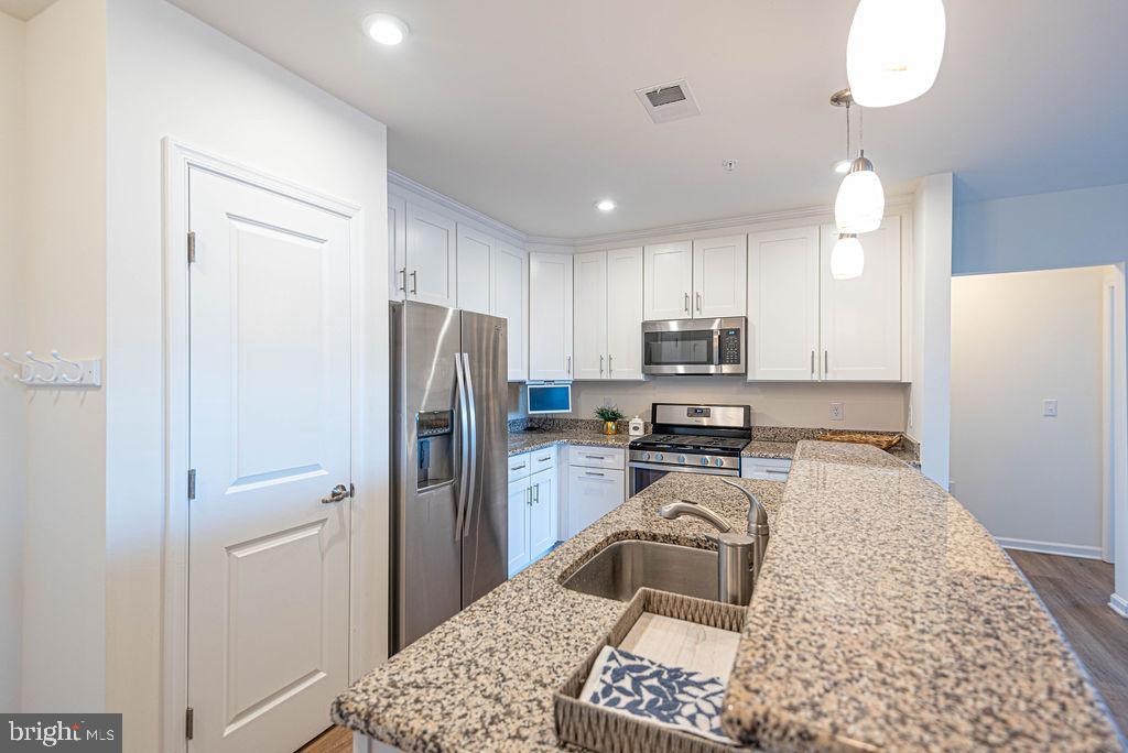20141 Riesling Lane, Unit 106 Lewes, DE 19958 - Photo 10 of 31 a kitchen with a refrigerator stove and sink