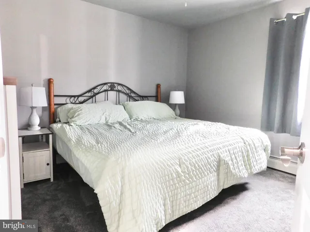 a large bed sitting in a bedroom next to a window