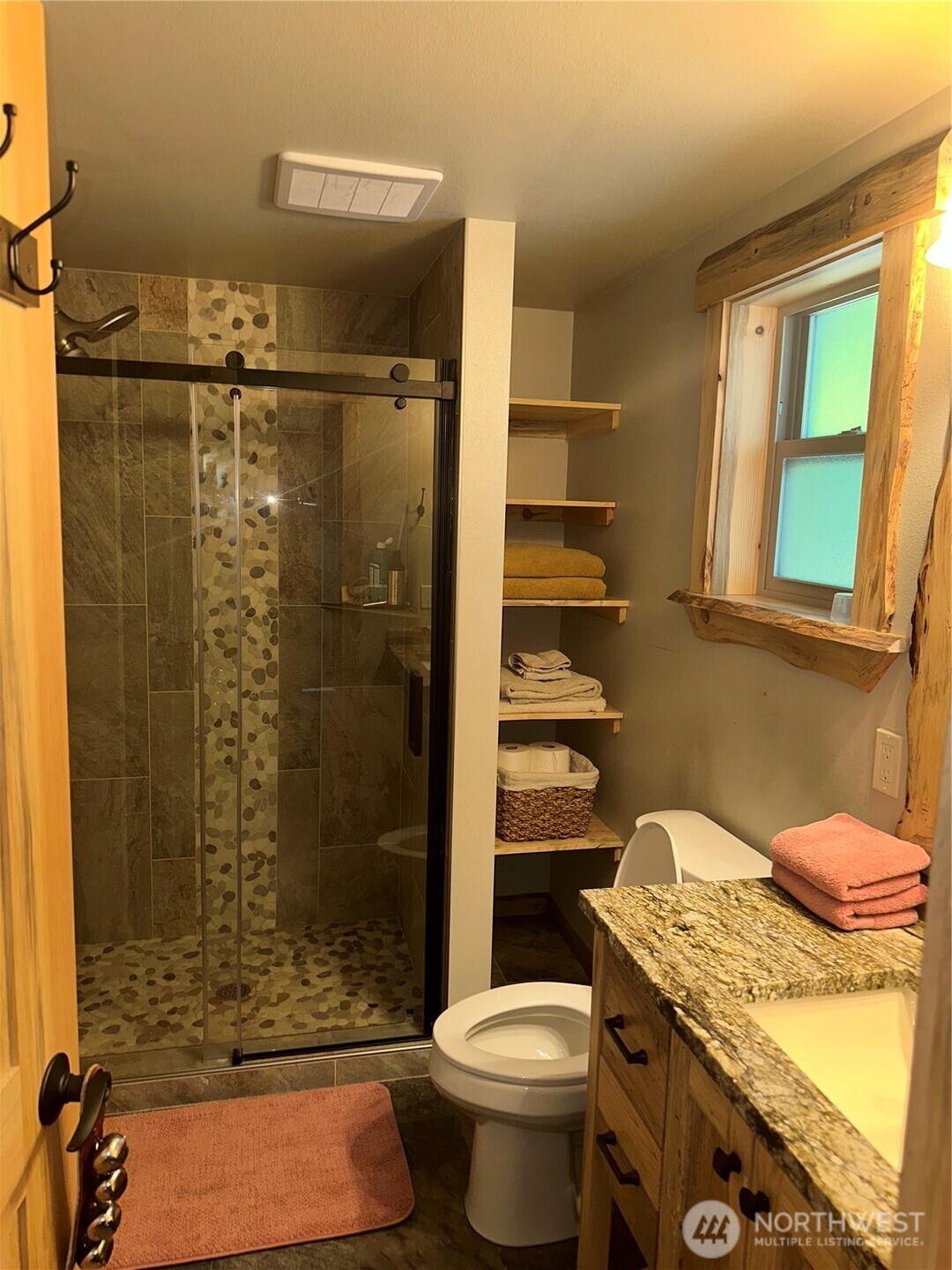 22415 Stirrup Road Leavenworth, WA 98826 - Photo 19 of 19 a bathroom with a granite countertop toilet a sink and shower