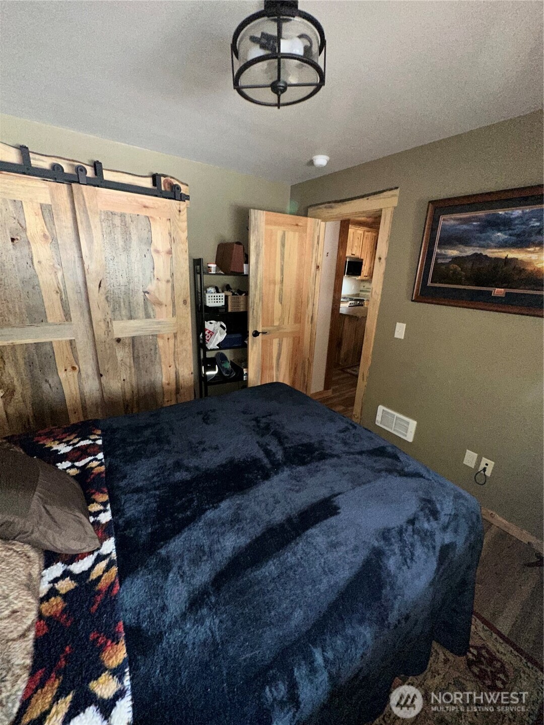 22415 Stirrup Road Leavenworth, WA 98826 - Photo 7 of 19 a bedroom with a large bed and a chandelier