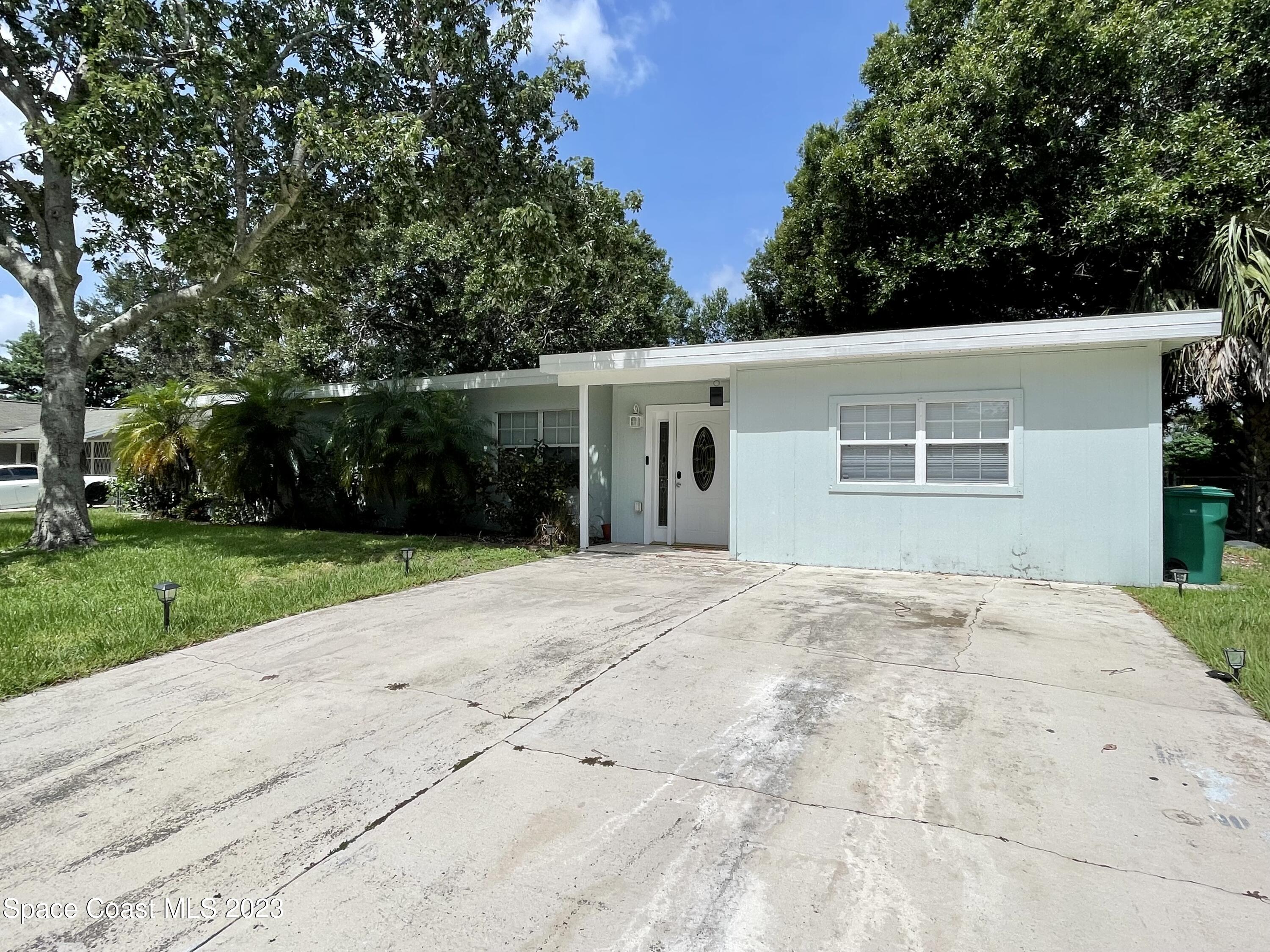 255 Lee Road Melbourne, FL 32904 - Photo 1 of 20 front view of a house with a yard and a garage