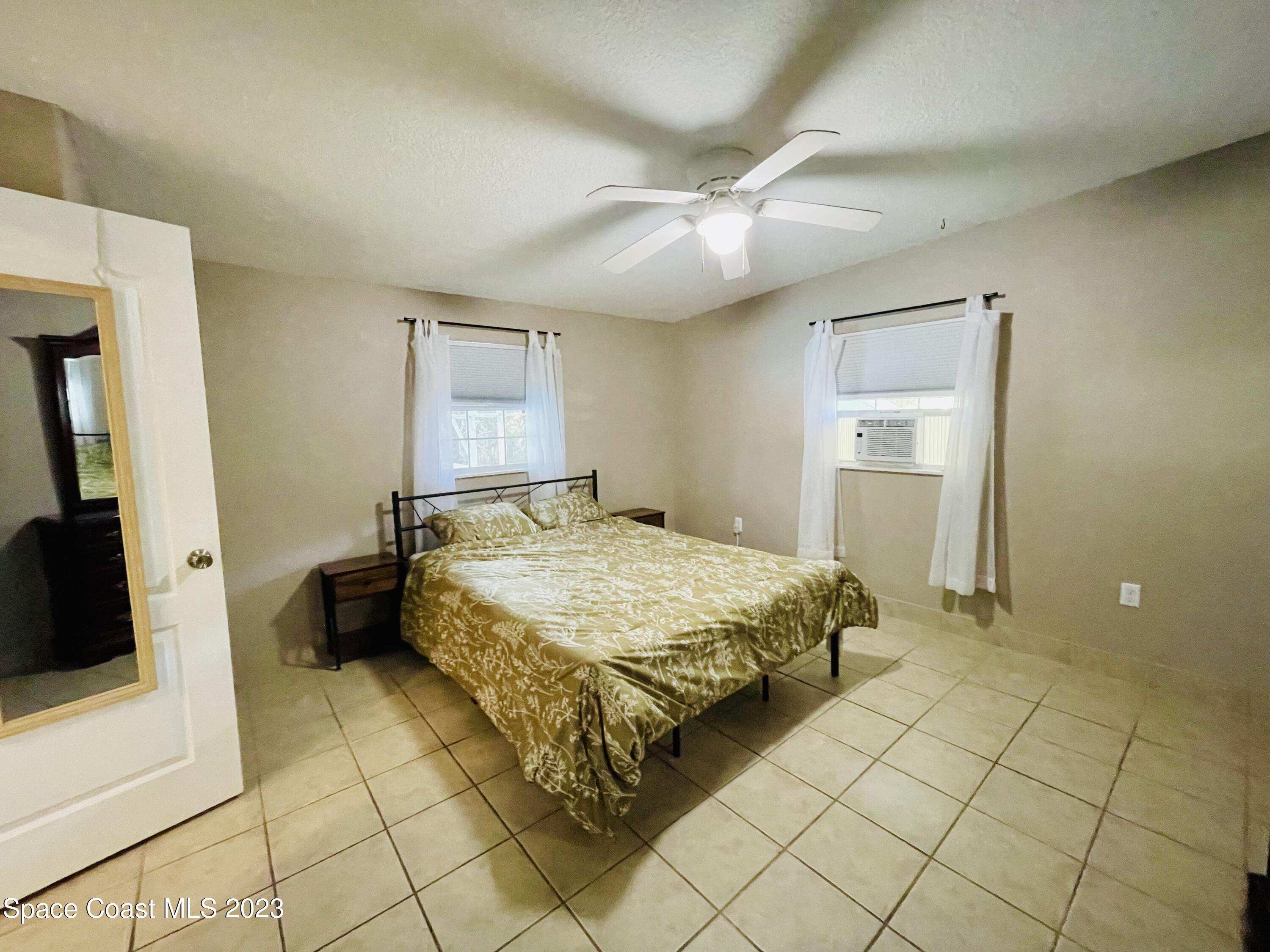 255 Lee Road Melbourne, FL 32904 - Photo 11 of 20 a spacious bedroom with a bed and a walk in closet