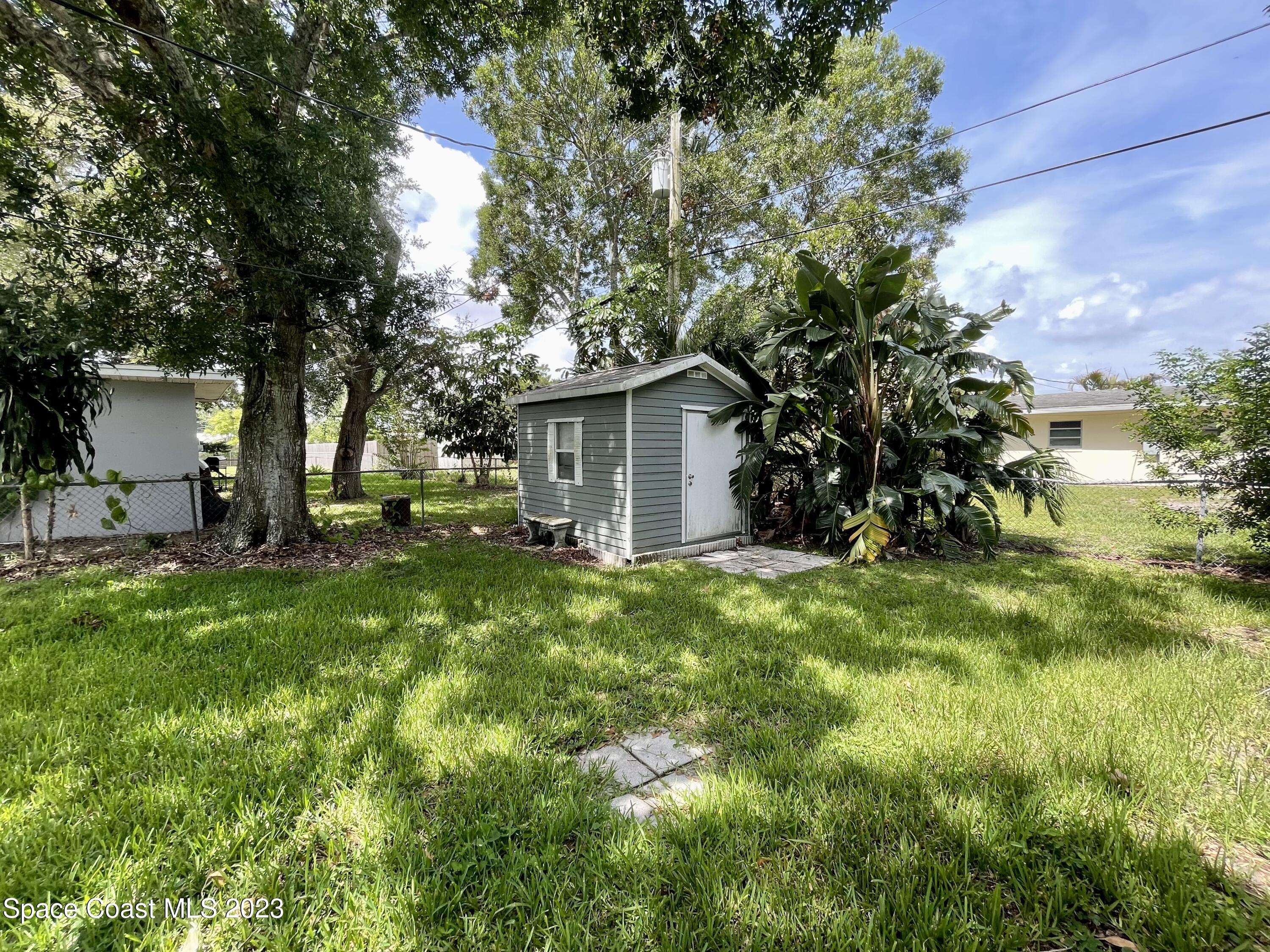 255 Lee Road Melbourne, FL 32904 - Photo 15 of 20 a view of a backyard with table and chairs and potted plants