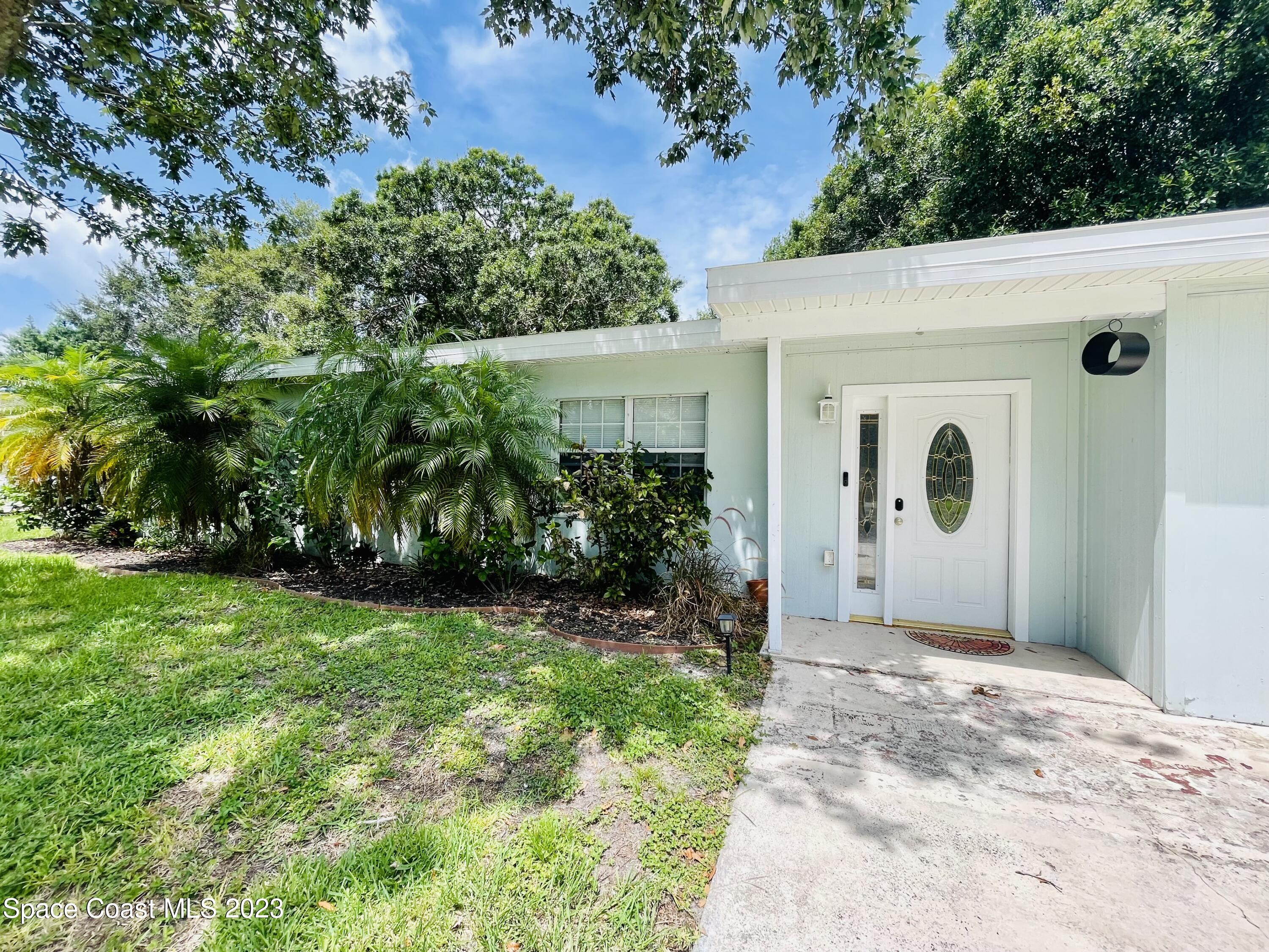 255 Lee Road Melbourne, FL 32904 - Photo 2 of 20 a view of a door in front of a house with a large tree