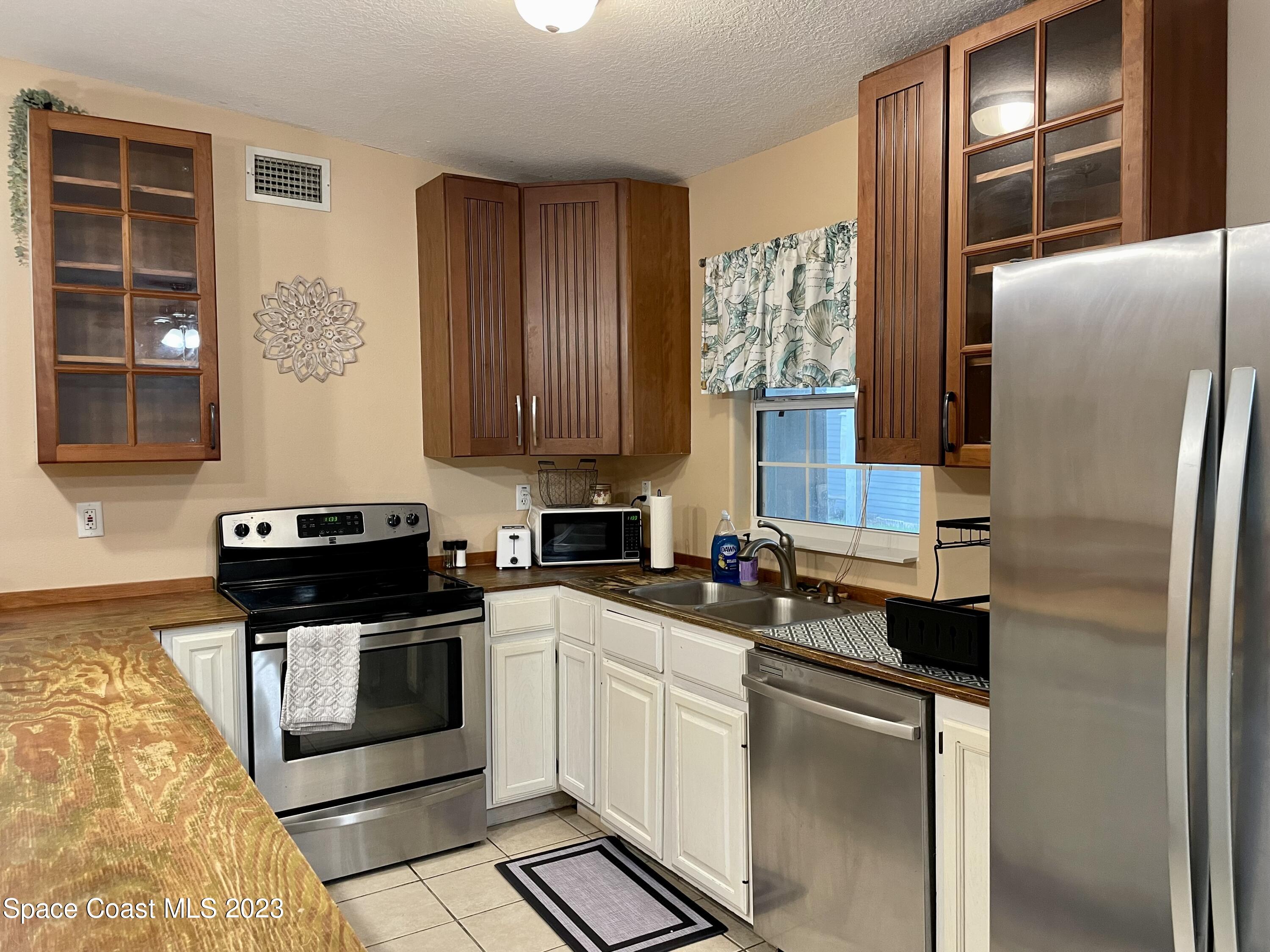 255 Lee Road Melbourne, FL 32904 - Photo 3 of 20 a kitchen with stainless steel appliances granite countertop a refrigerator sink and stove