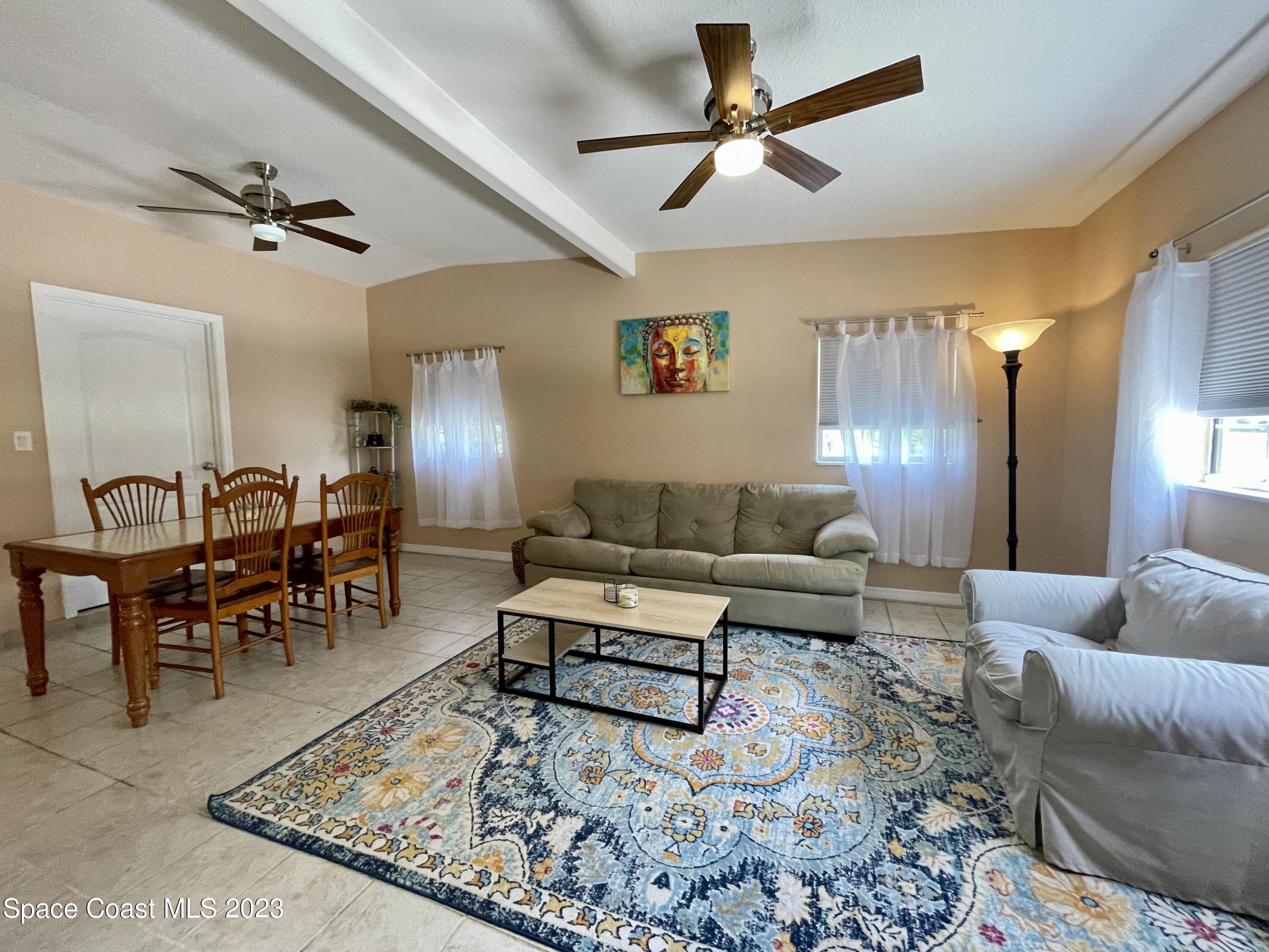 255 Lee Road Melbourne, FL 32904 - Photo 4 of 20 a living room with furniture a rug and a chandelier