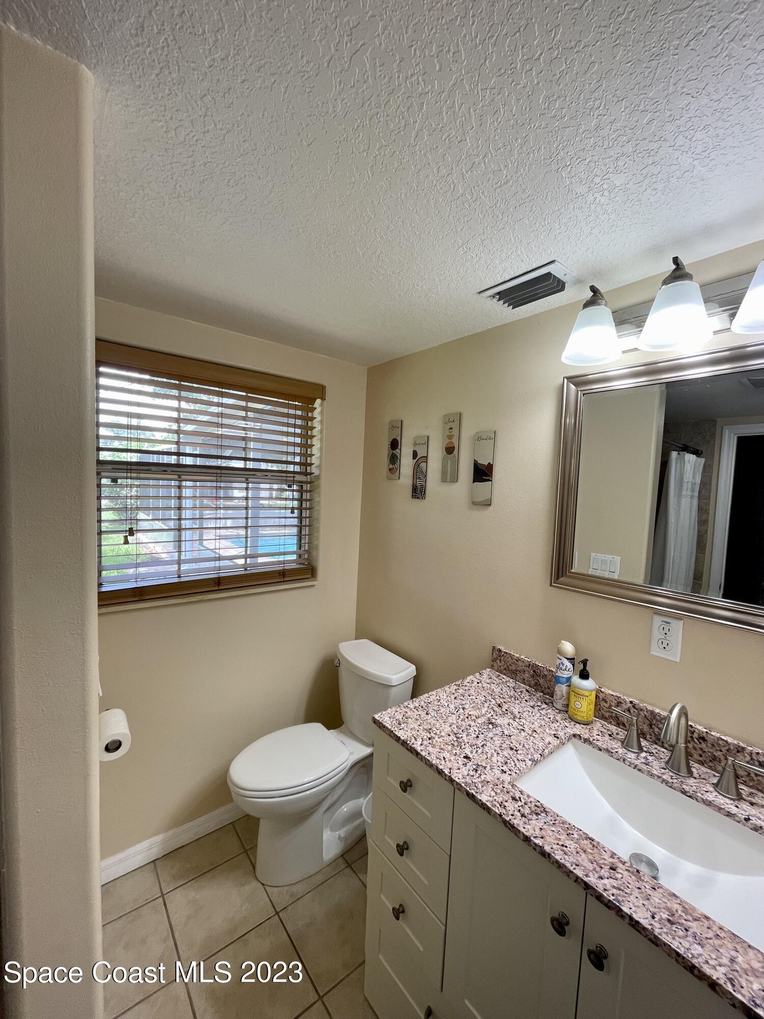 255 Lee Road Melbourne, FL 32904 - Photo 8 of 20 a bathroom with a toilet sink and mirror
