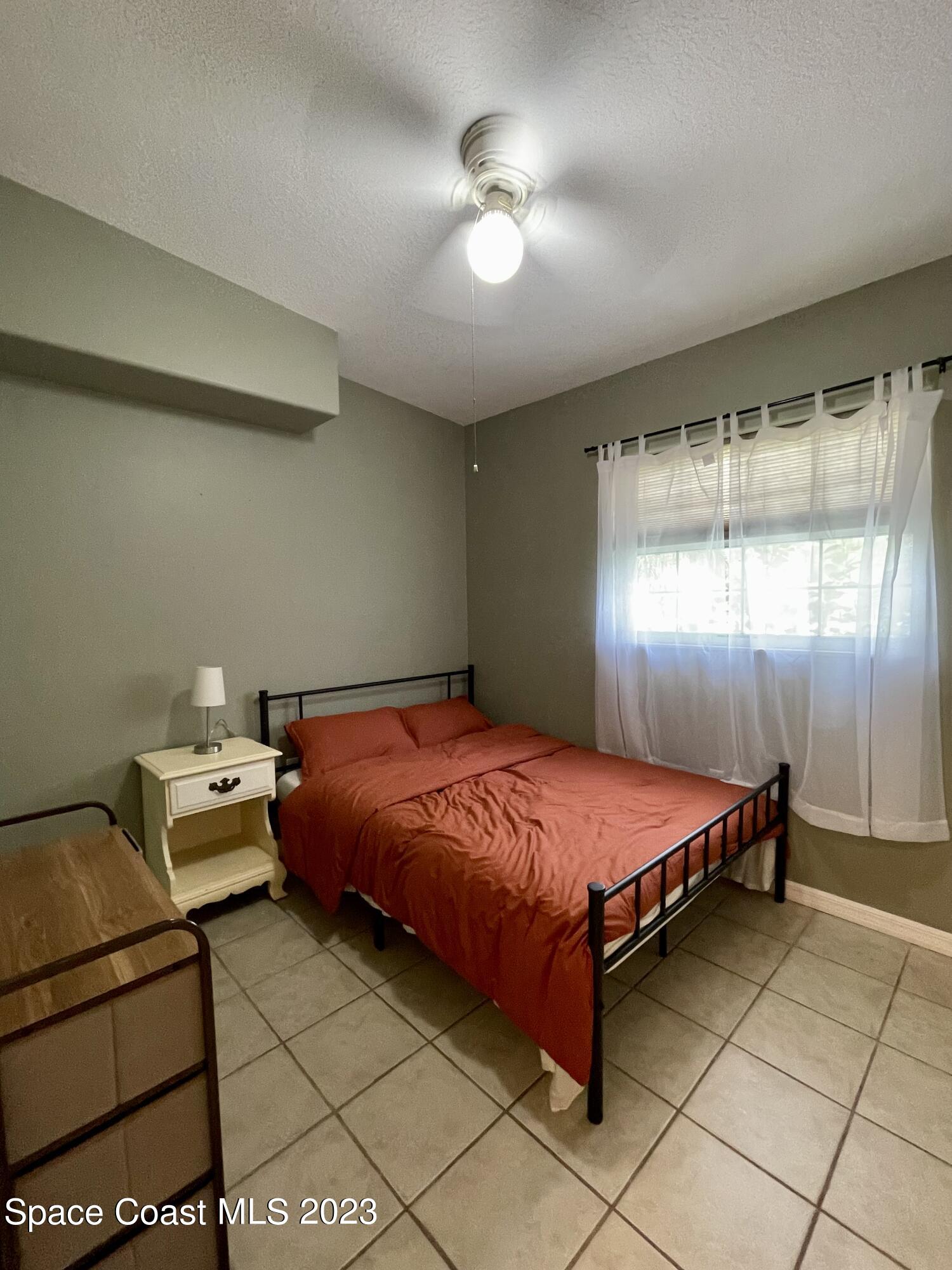 255 Lee Road Melbourne, FL 32904 - Photo 10 of 20 a spacious bedroom with a bed and a chandelier