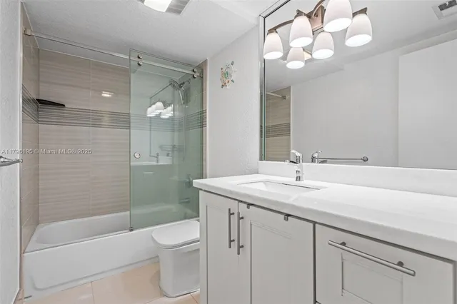 a bathroom with a granite countertop sink a toilet and shower